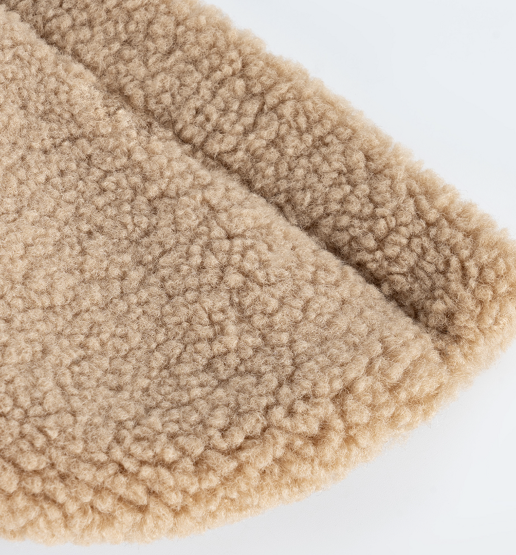 Detailfoto van de stof van de beige teddy jas